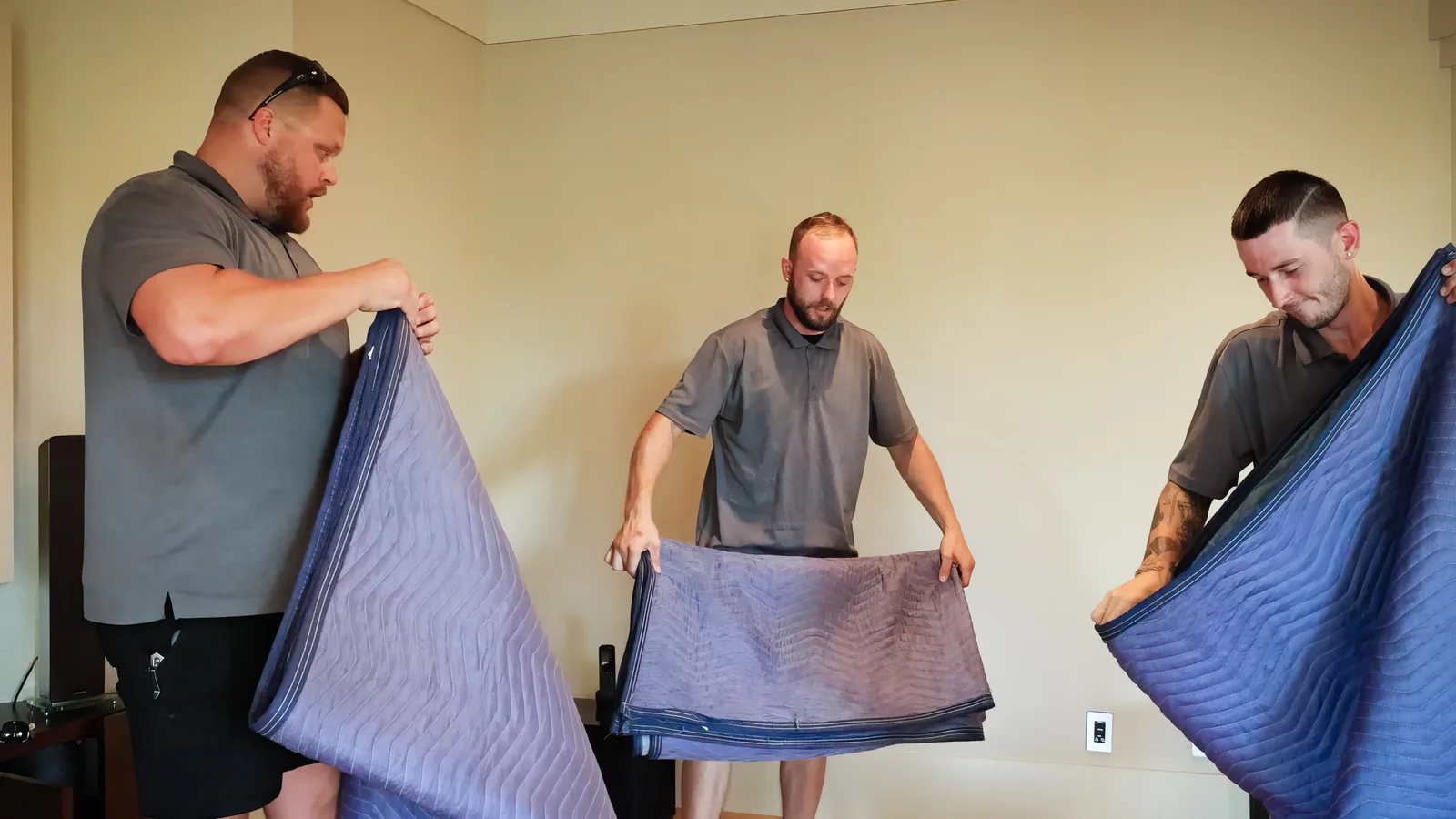 Trent movers preparing protective moving blankets for heavy lifting